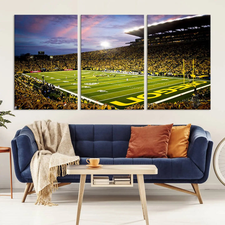 The living room showcases a triptych titled "University of Oregon Ducks Football Team Print - Eugene Autzen Stadium Wall Art Canvas Print," exhibiting a football stadium at sunset with a premium gallery-quality finish.