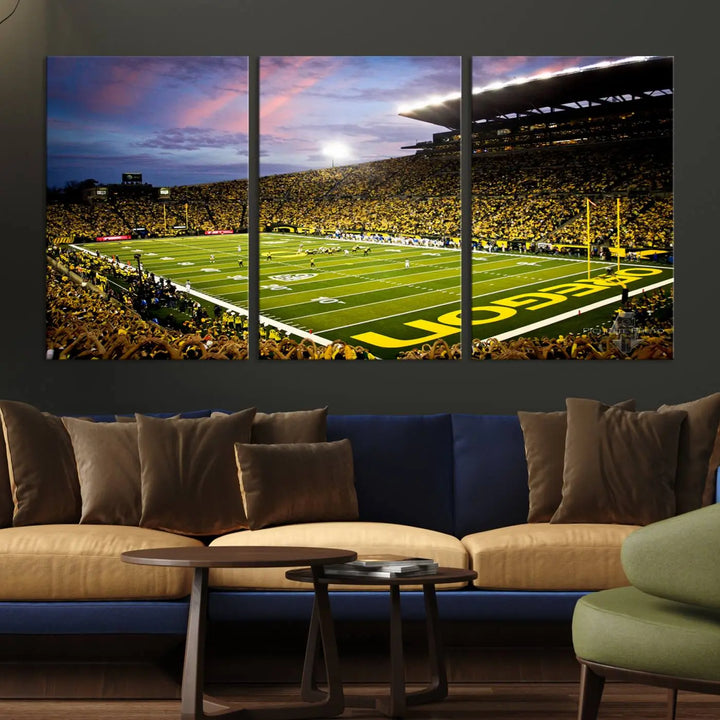 The living room showcases a triptych titled "University of Oregon Ducks Football Team Print - Eugene Autzen Stadium Wall Art Canvas Print," exhibiting a football stadium at sunset with a premium gallery-quality finish.