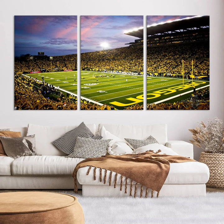 The living room showcases a triptych titled "University of Oregon Ducks Football Team Print - Eugene Autzen Stadium Wall Art Canvas Print," exhibiting a football stadium at sunset with a premium gallery-quality finish.