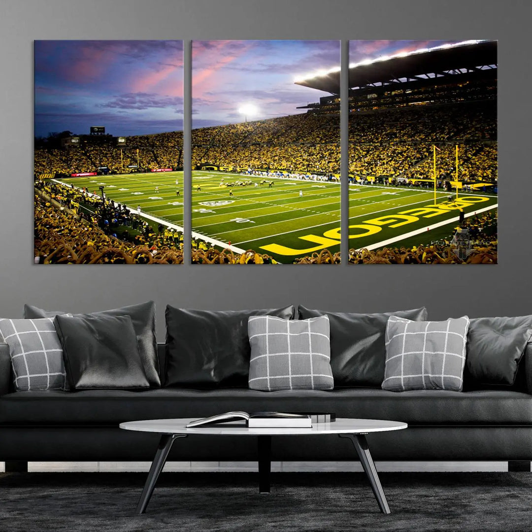 The living room showcases a triptych titled "University of Oregon Ducks Football Team Print - Eugene Autzen Stadium Wall Art Canvas Print," exhibiting a football stadium at sunset with a premium gallery-quality finish.