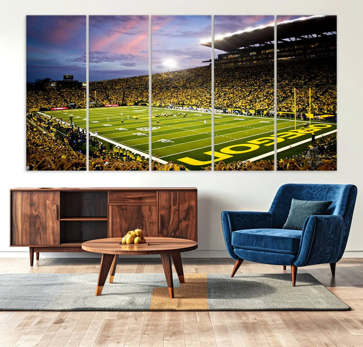 The living room showcases a triptych titled "University of Oregon Ducks Football Team Print - Eugene Autzen Stadium Wall Art Canvas Print," exhibiting a football stadium at sunset with a premium gallery-quality finish.