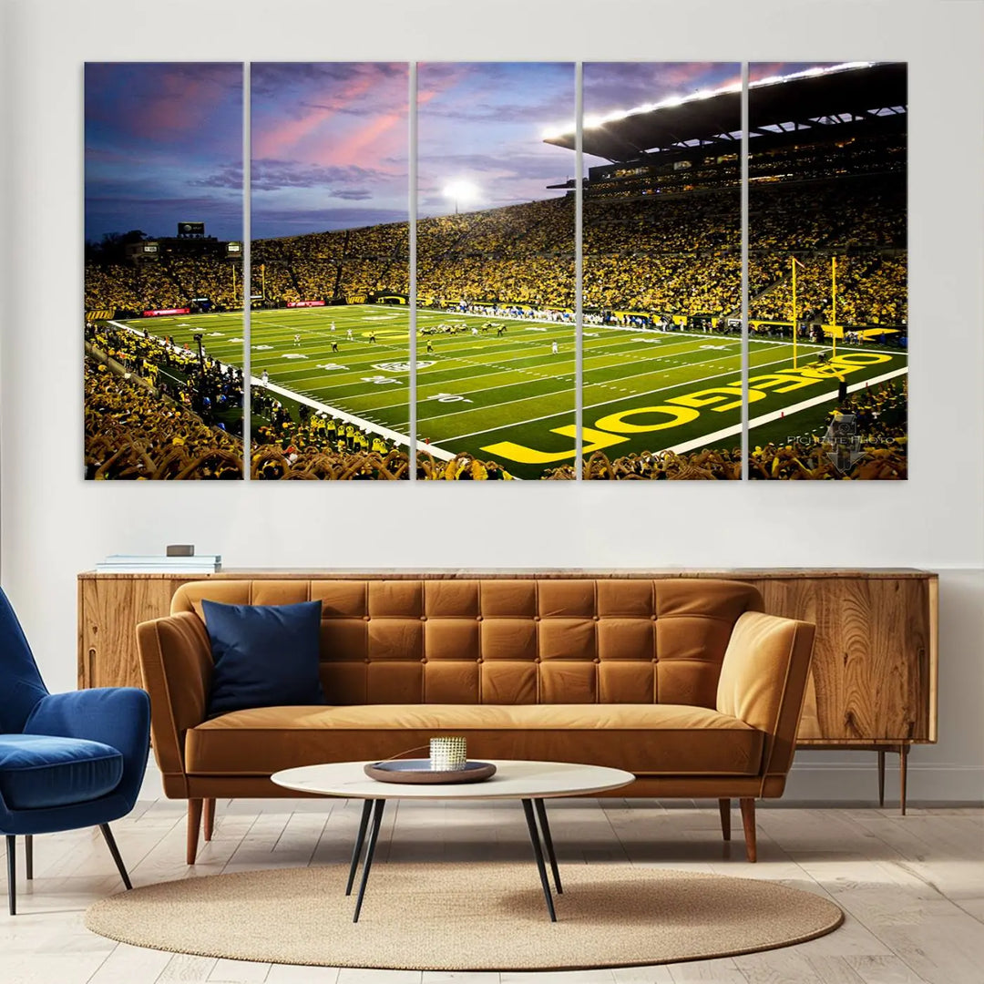 The living room showcases a triptych titled "University of Oregon Ducks Football Team Print - Eugene Autzen Stadium Wall Art Canvas Print," exhibiting a football stadium at sunset with a premium gallery-quality finish.