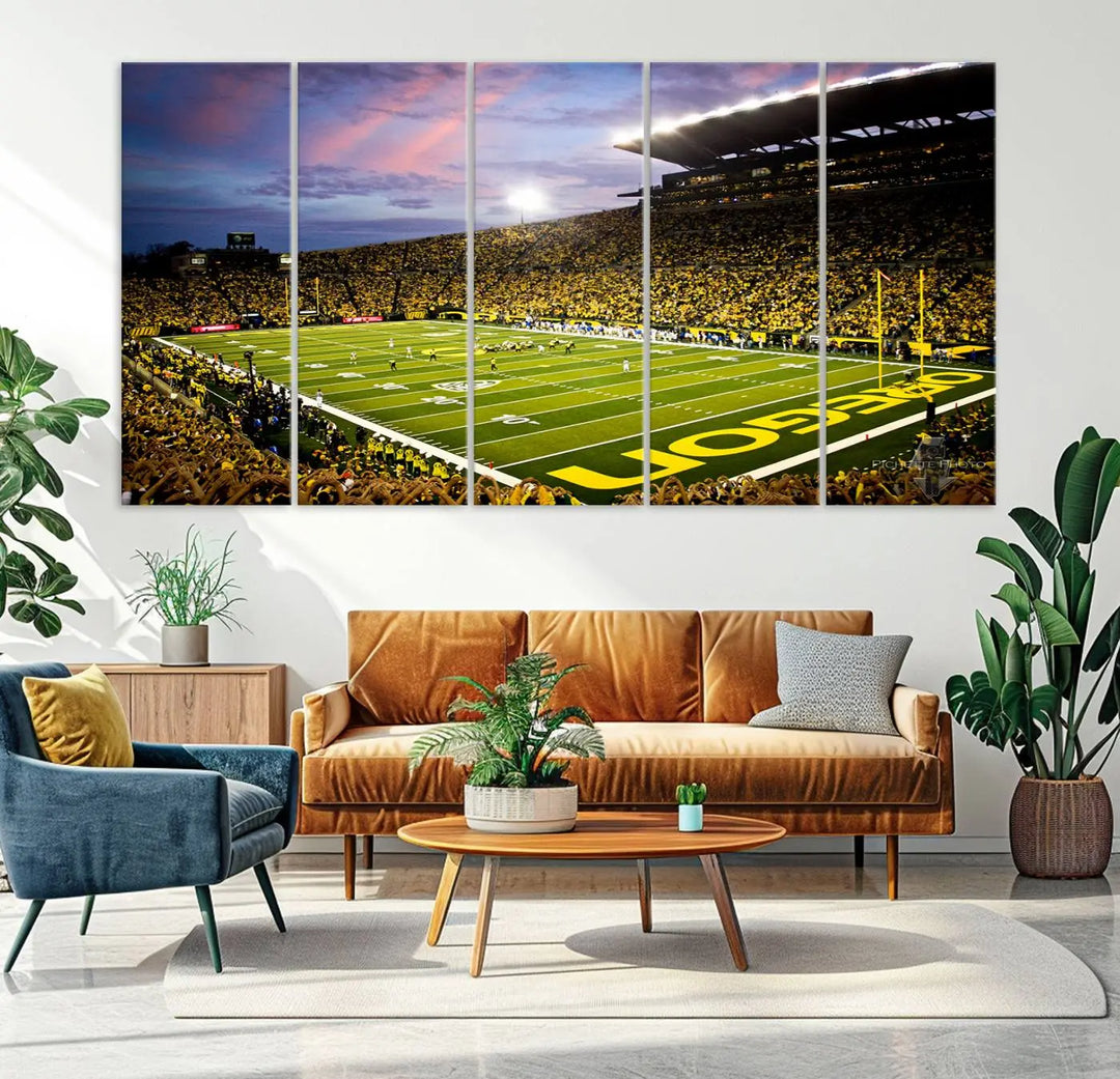 The living room showcases a triptych titled "University of Oregon Ducks Football Team Print - Eugene Autzen Stadium Wall Art Canvas Print," exhibiting a football stadium at sunset with a premium gallery-quality finish.