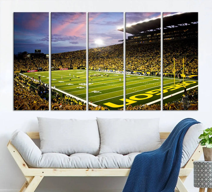 The living room showcases a triptych titled "University of Oregon Ducks Football Team Print - Eugene Autzen Stadium Wall Art Canvas Print," exhibiting a football stadium at sunset with a premium gallery-quality finish.