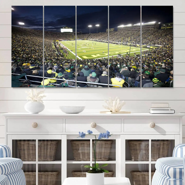 The living room features a triptych of wall art titled "University of Oregon Ducks Football Team Print - Eugene Autzen Stadium Wall Art Canvas Print," which depicts a bustling football stadium at night. Crafted on premium canvas and handmade in the USA, it serves as a striking focal point in the space.