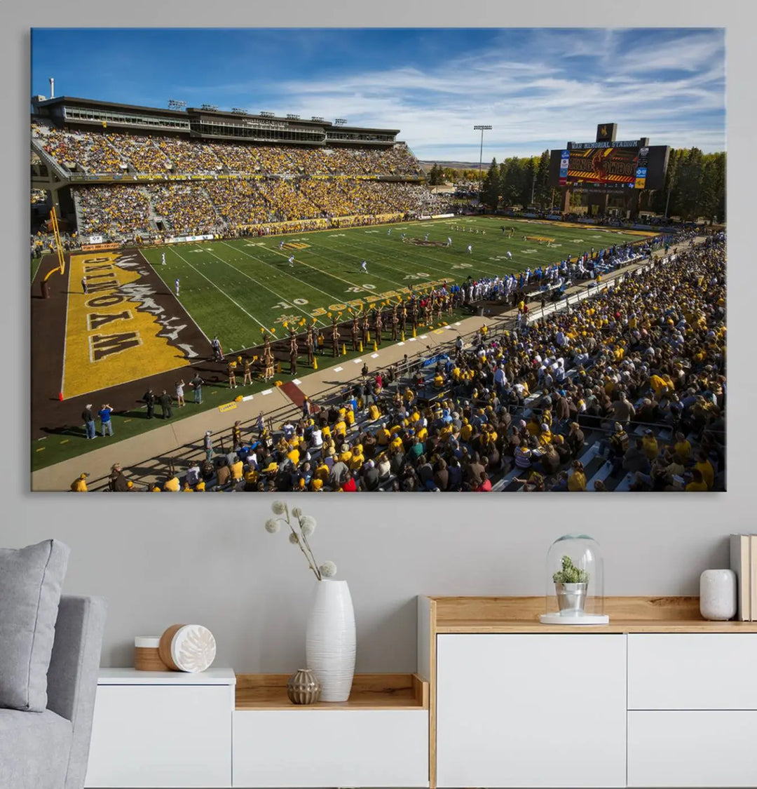 A premium canvas triptych, handmade in the USA, features the University of Wyoming Cowboys Football Team at Laramie Jonah Field as striking wall art on a beige wall.