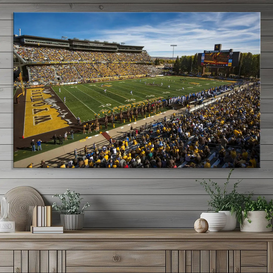 A premium canvas triptych, handmade in the USA, features the University of Wyoming Cowboys Football Team at Laramie Jonah Field as striking wall art on a beige wall.