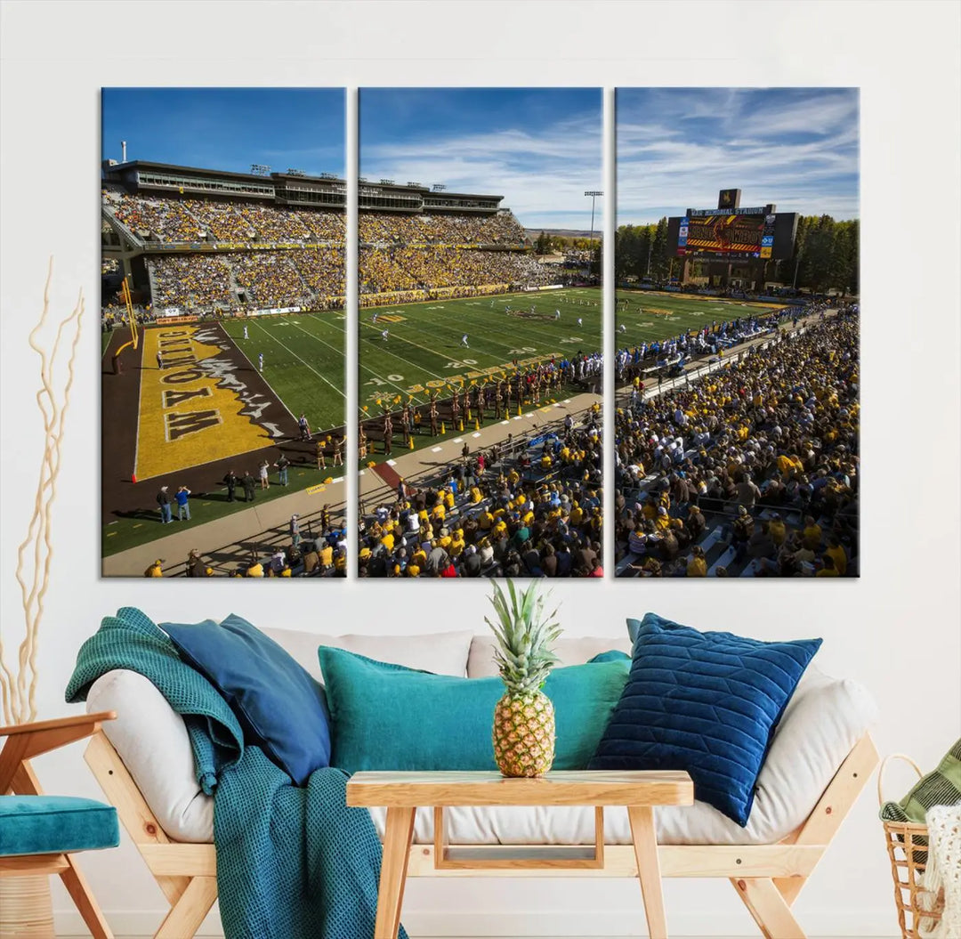 A premium canvas triptych, handmade in the USA, features the University of Wyoming Cowboys Football Team at Laramie Jonah Field as striking wall art on a beige wall.