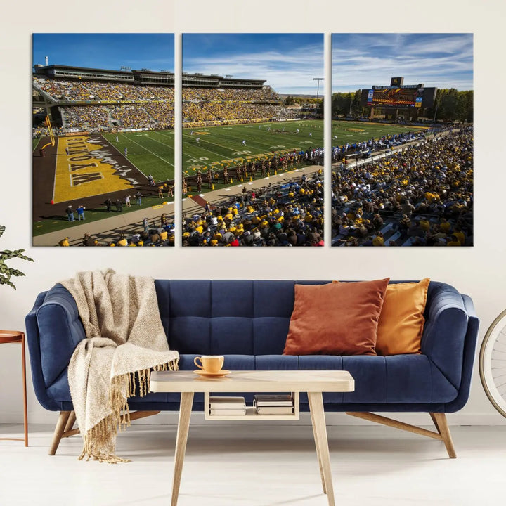 A premium canvas triptych, handmade in the USA, features the University of Wyoming Cowboys Football Team at Laramie Jonah Field as striking wall art on a beige wall.