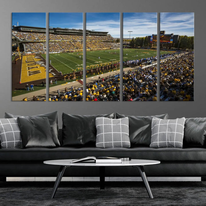 A premium canvas triptych, handmade in the USA, features the University of Wyoming Cowboys Football Team at Laramie Jonah Field as striking wall art on a beige wall.