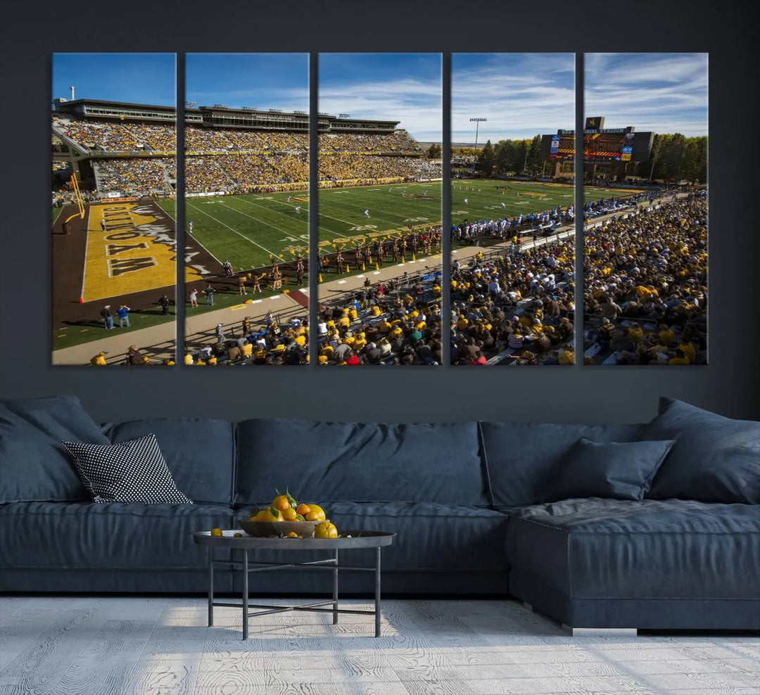 A premium canvas triptych, handmade in the USA, features the University of Wyoming Cowboys Football Team at Laramie Jonah Field as striking wall art on a beige wall.