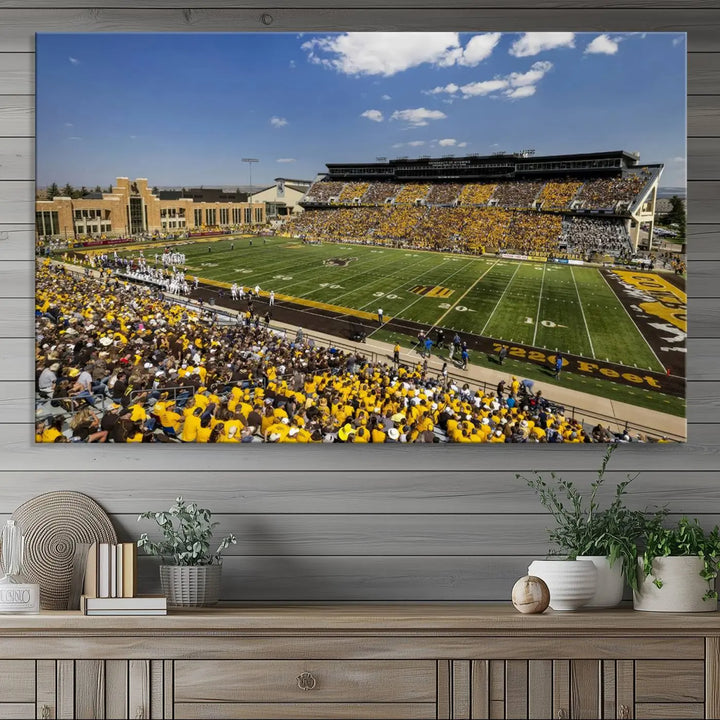 A University of Wyoming Cowboys Football Team print, featuring Laramie Jonah Field at War Memorial Stadium on a premium canvas, is displayed in the room.