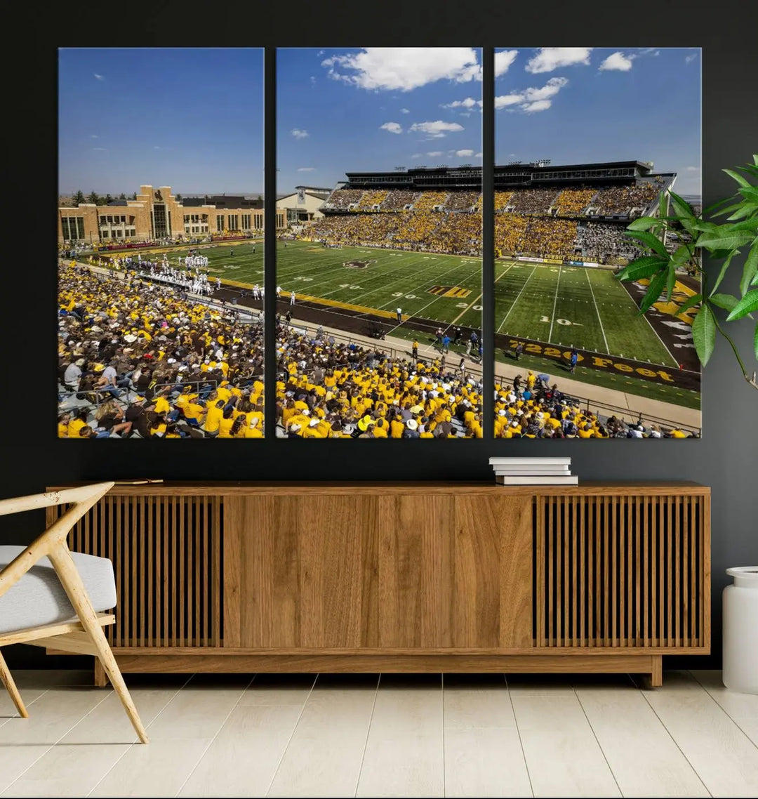 A University of Wyoming Cowboys Football Team print, featuring Laramie Jonah Field at War Memorial Stadium on a premium canvas, is displayed in the room.