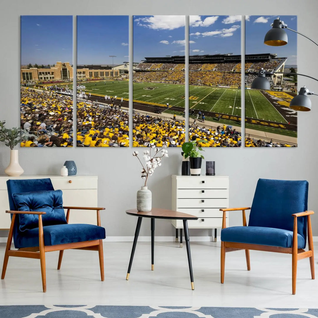 A University of Wyoming Cowboys Football Team print, featuring Laramie Jonah Field at War Memorial Stadium on a premium canvas, is displayed in the room.