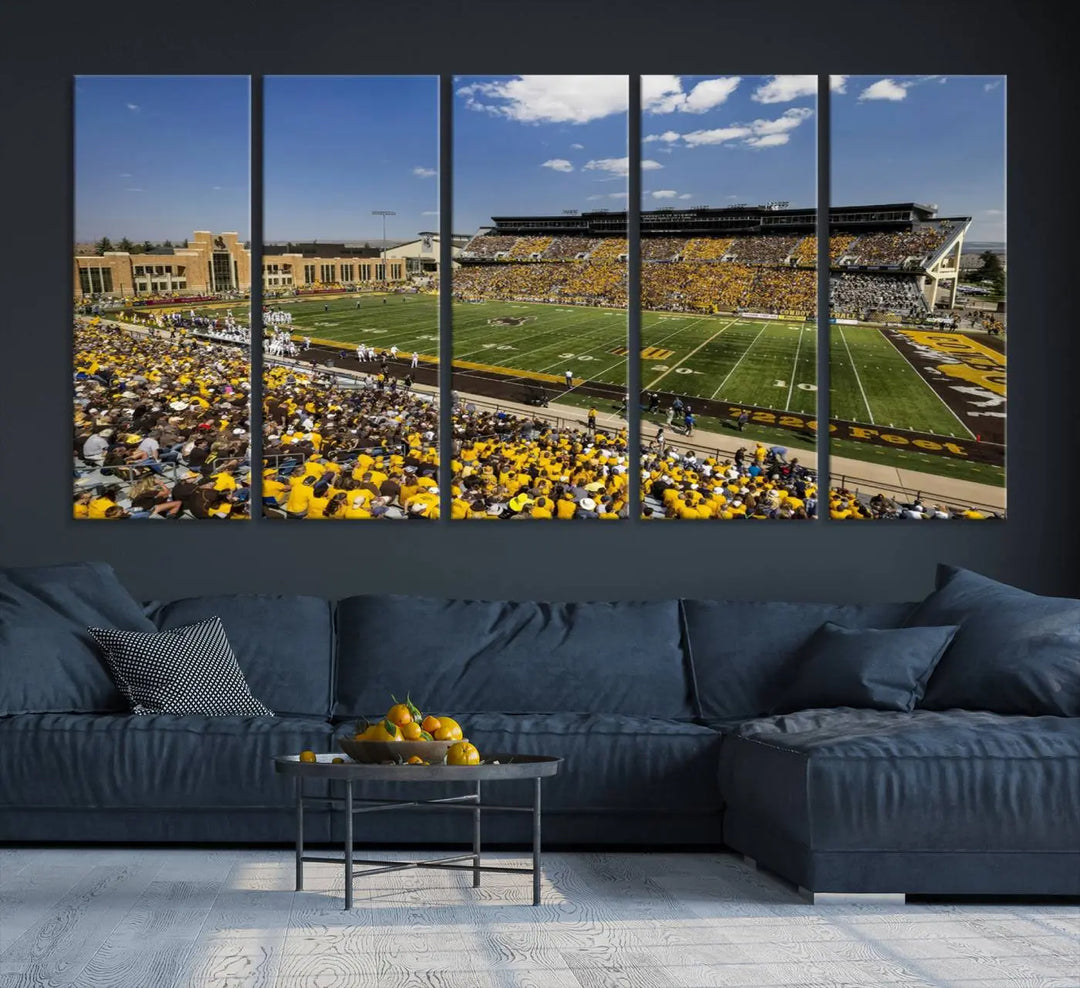 A University of Wyoming Cowboys Football Team print, featuring Laramie Jonah Field at War Memorial Stadium on a premium canvas, is displayed in the room.