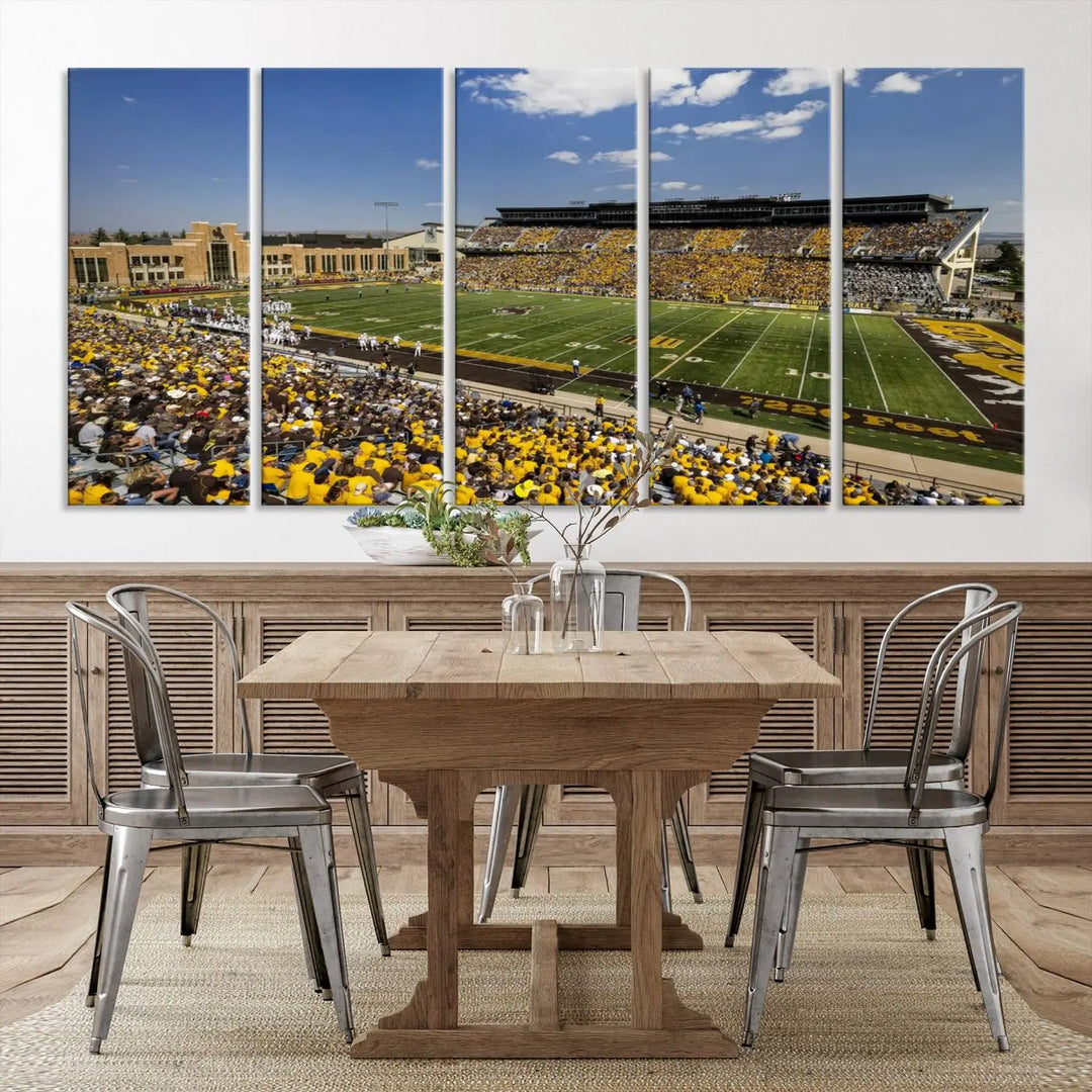 A University of Wyoming Cowboys Football Team print, featuring Laramie Jonah Field at War Memorial Stadium on a premium canvas, is displayed in the room.