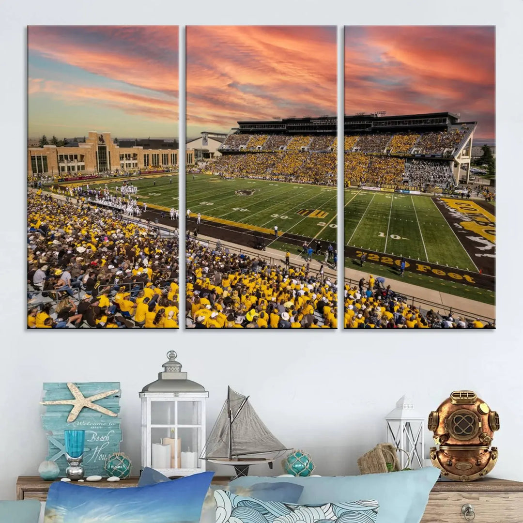 A living room wall showcases a stunning handmade canvas artwork featuring the lively University of Wyoming Cowboys football team at Jonah Field in War Memorial Stadium, beautifully set under a vibrant sunset sky.