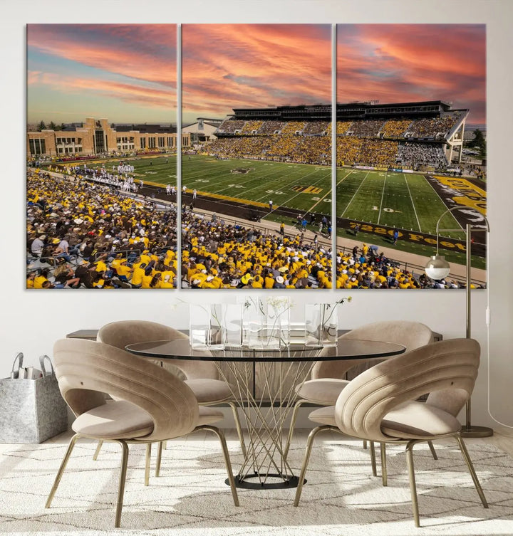 A living room wall showcases a stunning handmade canvas artwork featuring the lively University of Wyoming Cowboys football team at Jonah Field in War Memorial Stadium, beautifully set under a vibrant sunset sky.