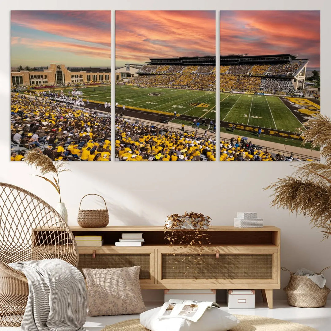 A living room wall showcases a stunning handmade canvas artwork featuring the lively University of Wyoming Cowboys football team at Jonah Field in War Memorial Stadium, beautifully set under a vibrant sunset sky.