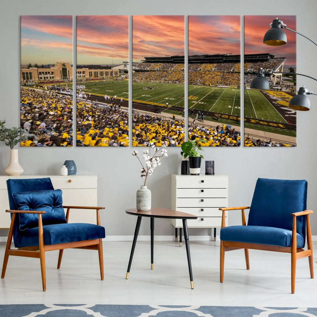 A living room wall showcases a stunning handmade canvas artwork featuring the lively University of Wyoming Cowboys football team at Jonah Field in War Memorial Stadium, beautifully set under a vibrant sunset sky.