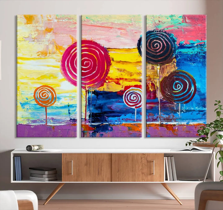 The Vibrant Lollipops Wall Art Canvas Print features a colorful abstract design of spiral trees set against a sunset background. This elegantly gallery-wrapped piece comes with a UV-protective coating, creating an impressive centerpiece in the room.