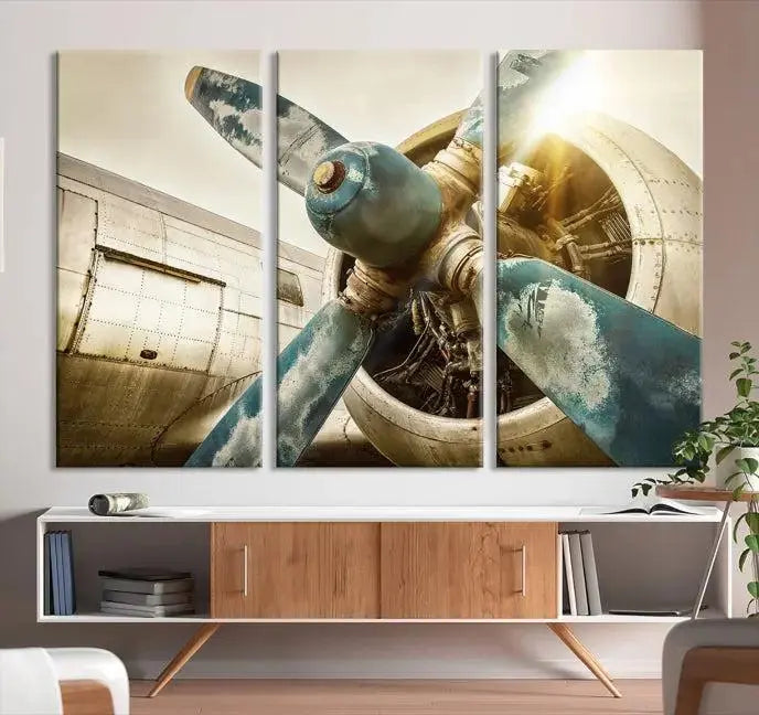 The Vintage Airplane Canvas Print, featuring a triptych design with an airplane propeller on museum-quality canvases with UV-protective coating, is displayed in a cozy living room.