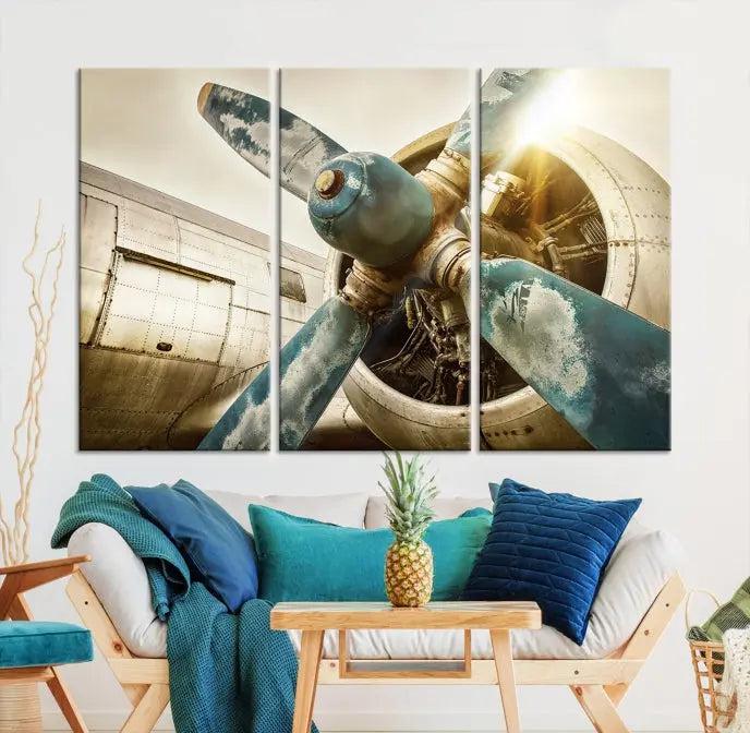 The Vintage Airplane Canvas Print, featuring a triptych design with an airplane propeller on museum-quality canvases with UV-protective coating, is displayed in a cozy living room.