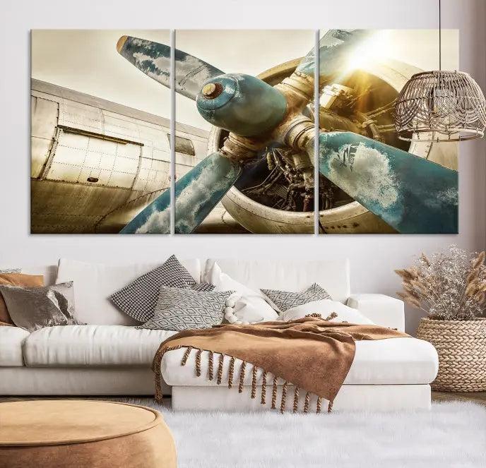 The Vintage Airplane Canvas Print, featuring a triptych design with an airplane propeller on museum-quality canvases with UV-protective coating, is displayed in a cozy living room.