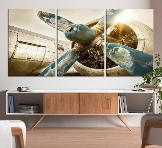 The Vintage Airplane Canvas Print, featuring a triptych design with an airplane propeller on museum-quality canvases with UV-protective coating, is displayed in a cozy living room.