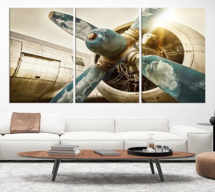 The Vintage Airplane Canvas Print, featuring a triptych design with an airplane propeller on museum-quality canvases with UV-protective coating, is displayed in a cozy living room.