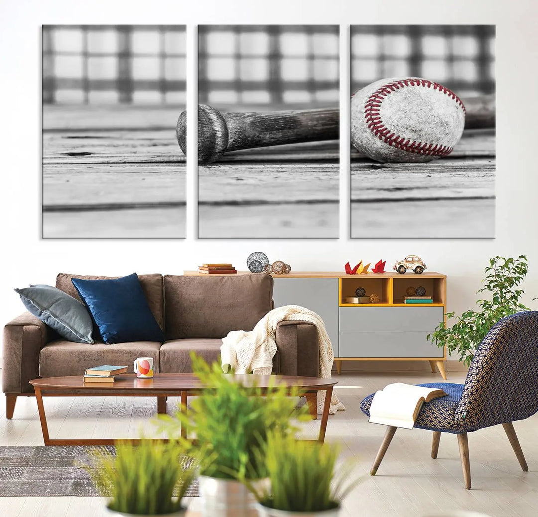 The Vintage Baseball Canvas Wall Art Print showcases a black and white photo of a baseball and bat on a wooden table, divided into three panels. Printed on museum-quality canvas with a UV-protective coating, this artwork arrives ready to hang, bringing timeless charm to any room.