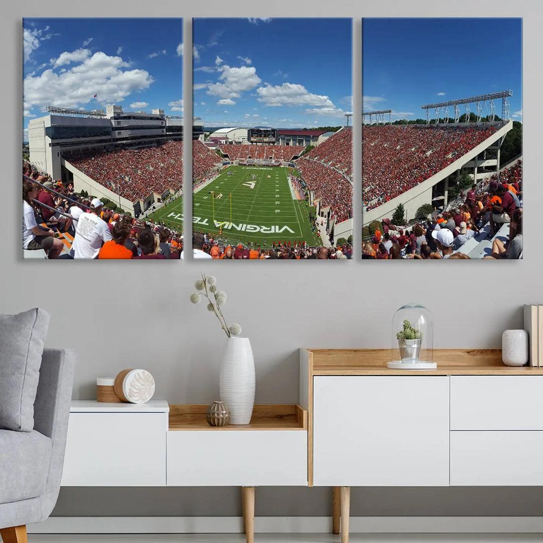 A gallery-quality triptych of the Virginia Tech Hokies Football Team, capturing the vibrant Blacksburg Lane Stadium, hangs in a well-lit, modern room. This handmade canvas artwork from the USA adds a dynamic touch to the space.