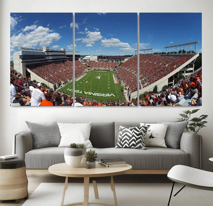 A gallery-quality triptych of the Virginia Tech Hokies Football Team, capturing the vibrant Blacksburg Lane Stadium, hangs in a well-lit, modern room. This handmade canvas artwork from the USA adds a dynamic touch to the space.