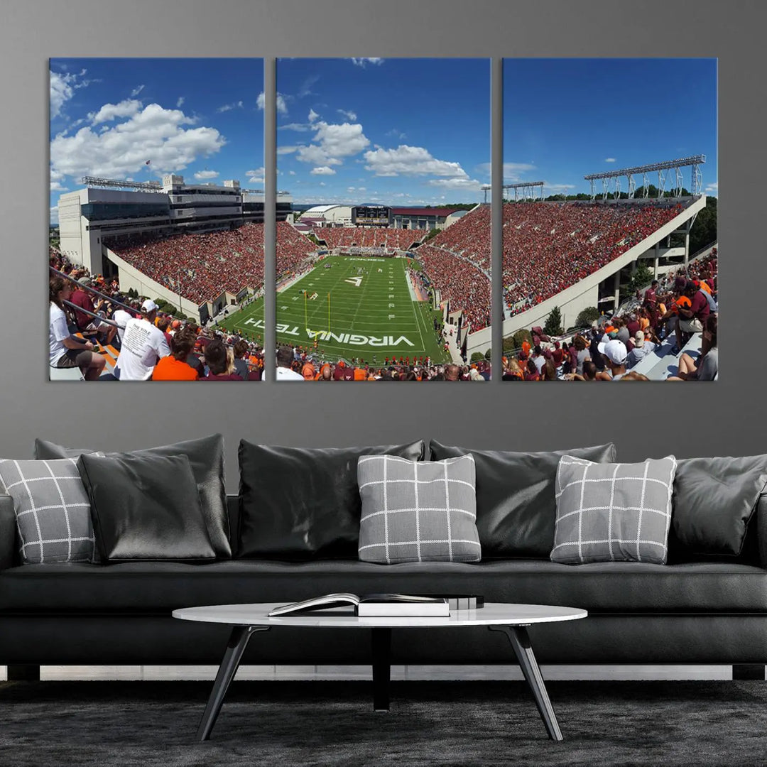 A gallery-quality triptych of the Virginia Tech Hokies Football Team, capturing the vibrant Blacksburg Lane Stadium, hangs in a well-lit, modern room. This handmade canvas artwork from the USA adds a dynamic touch to the space.