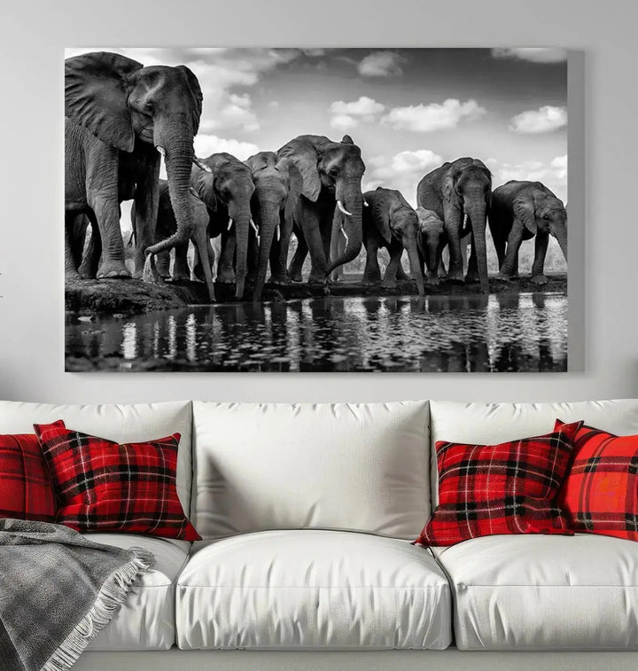 A stunning "Wall Art Animal Canvas Print" featuring a black and white photo of a herd of elephants drinking water is elegantly displayed, gallery wrapped on museum-quality canvas.