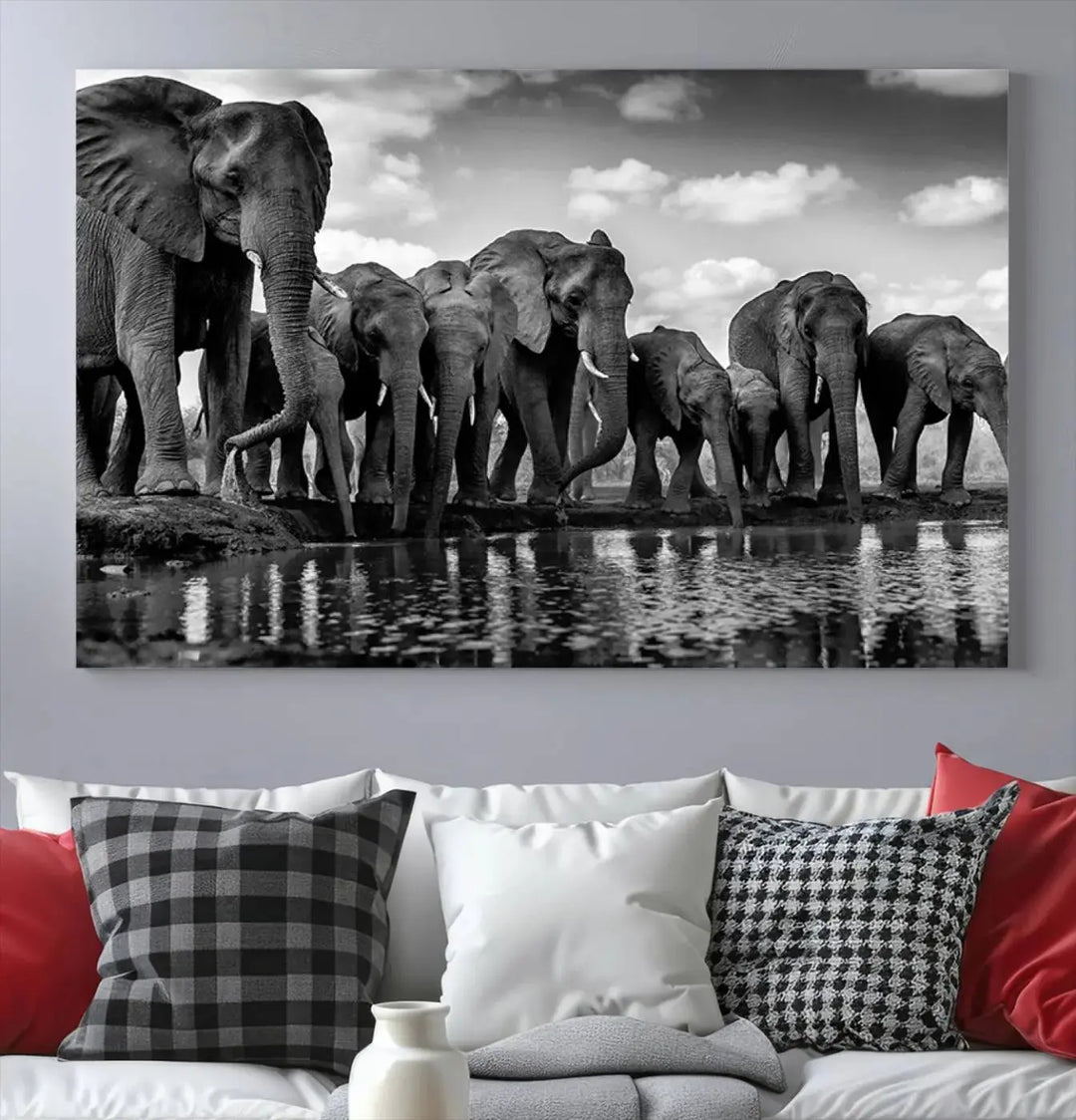 A stunning "Wall Art Animal Canvas Print" featuring a black and white photo of a herd of elephants drinking water is elegantly displayed, gallery wrapped on museum-quality canvas.