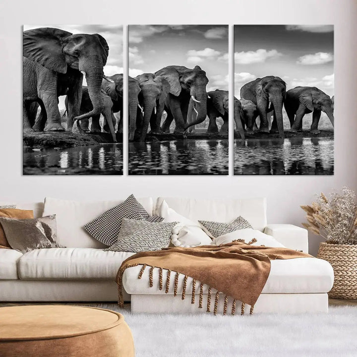 A stunning "Wall Art Animal Canvas Print" featuring a black and white photo of a herd of elephants drinking water is elegantly displayed, gallery wrapped on museum-quality canvas.