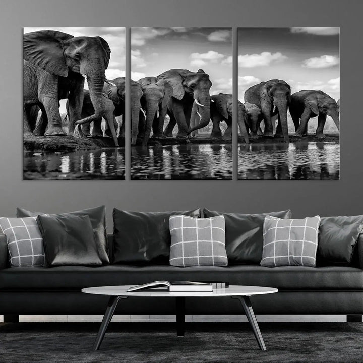 A stunning "Wall Art Animal Canvas Print" featuring a black and white photo of a herd of elephants drinking water is elegantly displayed, gallery wrapped on museum-quality canvas.