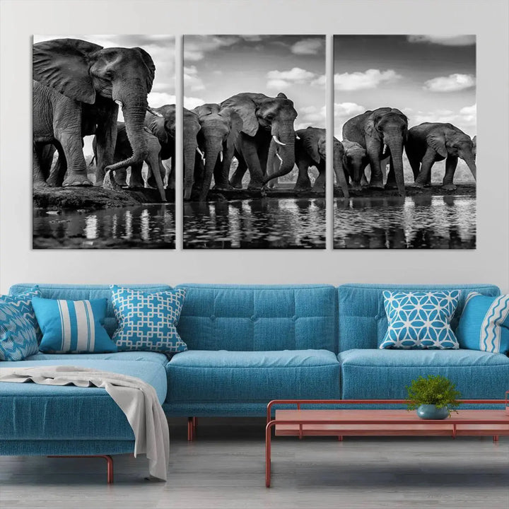 A stunning "Wall Art Animal Canvas Print" featuring a black and white photo of a herd of elephants drinking water is elegantly displayed, gallery wrapped on museum-quality canvas.