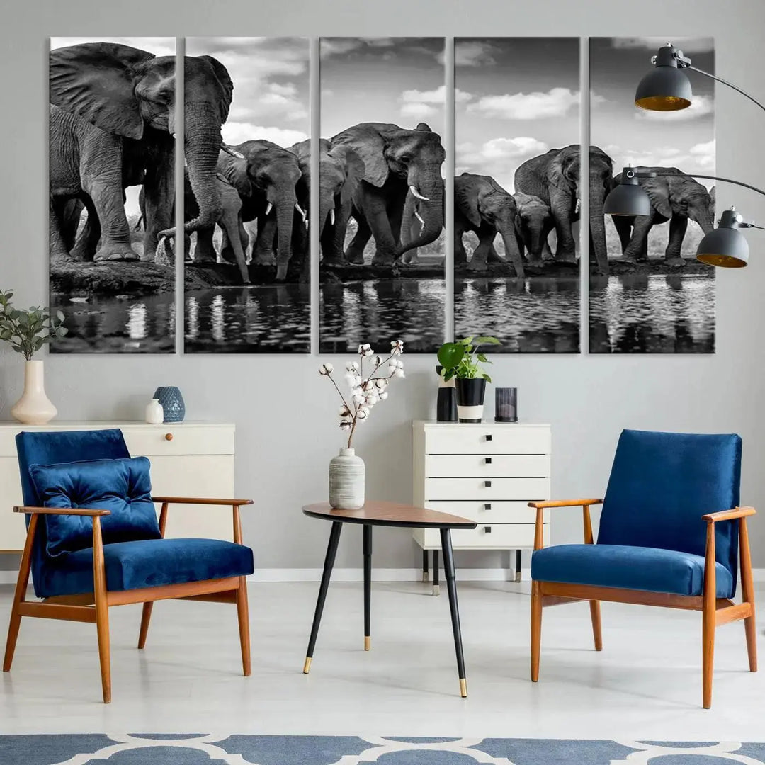 A stunning "Wall Art Animal Canvas Print" featuring a black and white photo of a herd of elephants drinking water is elegantly displayed, gallery wrapped on museum-quality canvas.