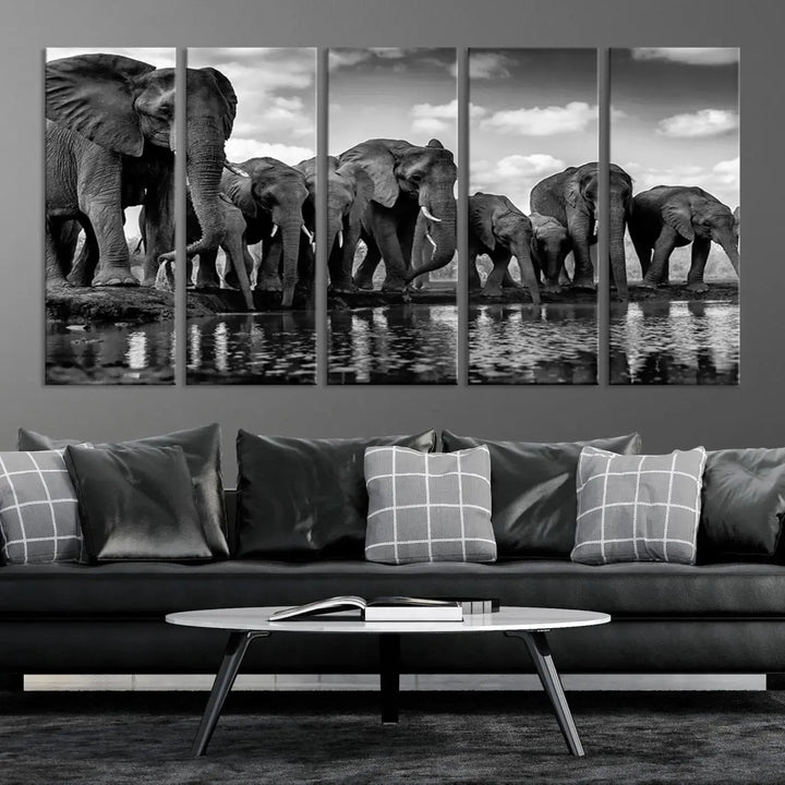 A stunning "Wall Art Animal Canvas Print" featuring a black and white photo of a herd of elephants drinking water is elegantly displayed, gallery wrapped on museum-quality canvas.