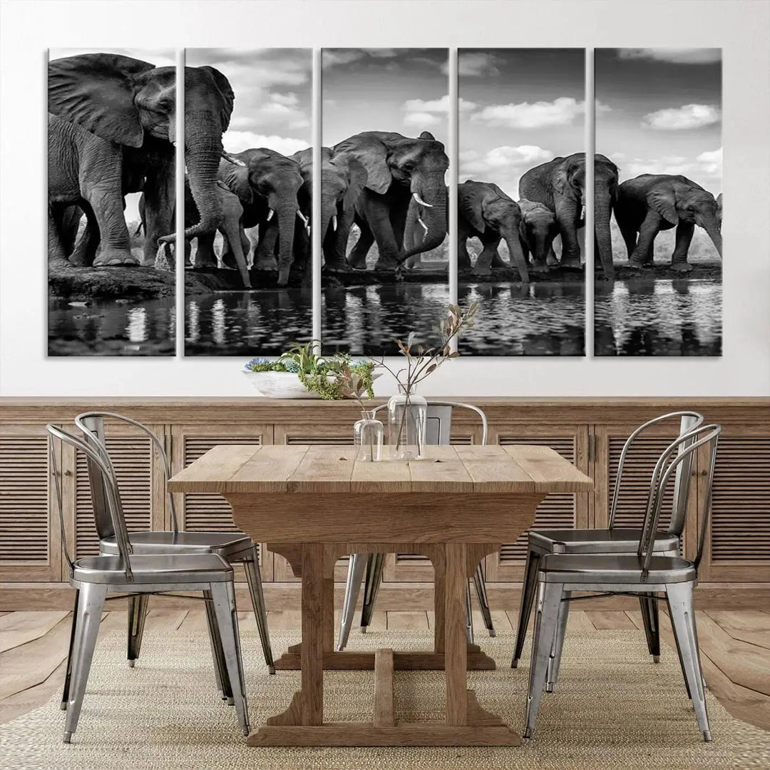 A stunning "Wall Art Animal Canvas Print" featuring a black and white photo of a herd of elephants drinking water is elegantly displayed, gallery wrapped on museum-quality canvas.