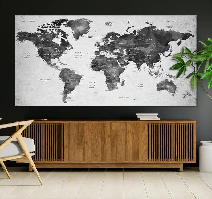 The "Wall Art Gray Black World Map Print" triptych, elegantly gallery wrapped on museum-quality canvas, adorns the wall.