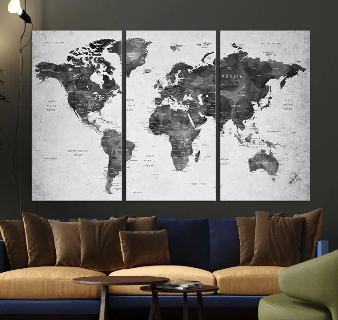 The "Wall Art Gray Black World Map Print" triptych, elegantly gallery wrapped on museum-quality canvas, adorns the wall.