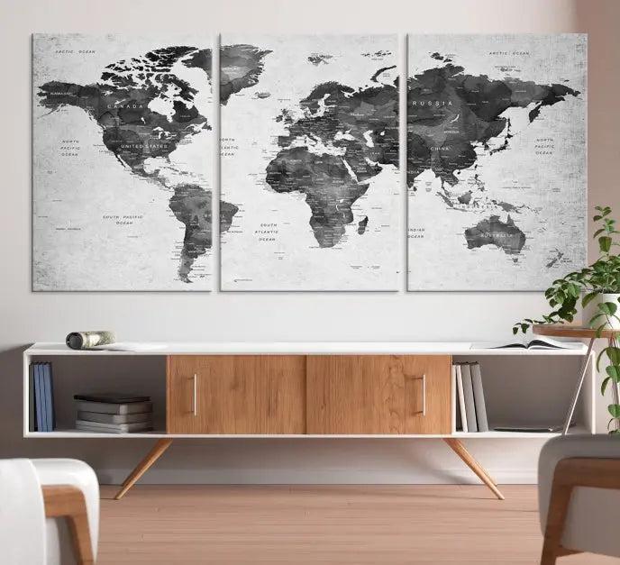 The "Wall Art Gray Black World Map Print" triptych, elegantly gallery wrapped on museum-quality canvas, adorns the wall.