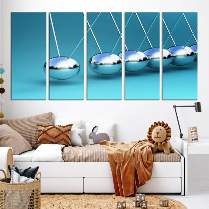 The Wall Art Newton's Cradle Canvas Print is displayed as a triptych on a teal background. Each piece is gallery-wrapped and crafted on museum-quality canvases with a UV-protective coating, ensuring lasting vibrancy and protection.