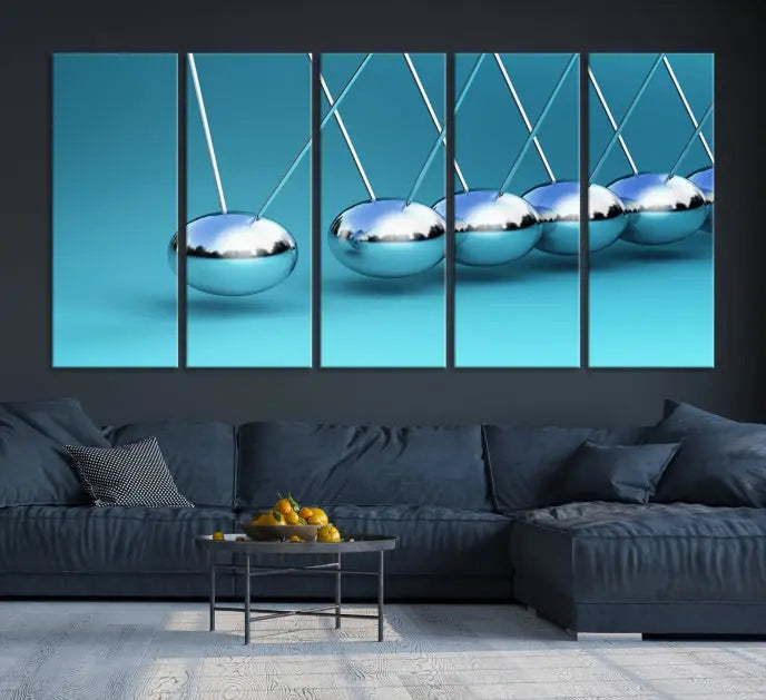 The Wall Art Newton's Cradle Canvas Print is displayed as a triptych on a teal background. Each piece is gallery-wrapped and crafted on museum-quality canvases with a UV-protective coating, ensuring lasting vibrancy and protection.