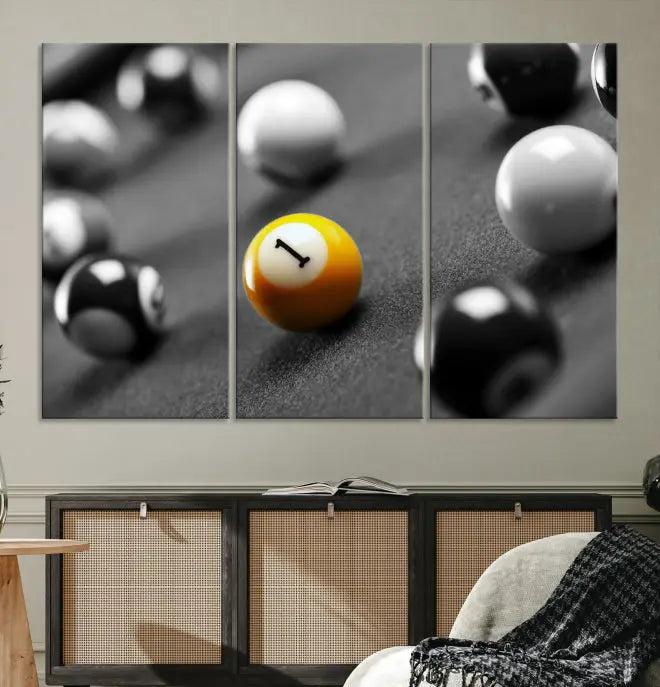 The Wall Art Pool Table and Balls Canvas Print features a triptych design with vibrant billiard balls, highlighting the yellow number 1 ball. This captivating piece is handmade in the USA on museum-quality canvas, offering an exquisite enhancement to your space. It comes with free shipping for your convenience.