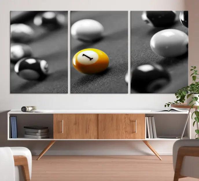 The Wall Art Pool Table and Balls Canvas Print features a triptych design with vibrant billiard balls, highlighting the yellow number 1 ball. This captivating piece is handmade in the USA on museum-quality canvas, offering an exquisite enhancement to your space. It comes with free shipping for your convenience.