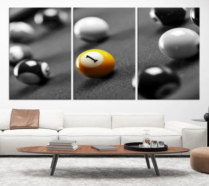 The Wall Art Pool Table and Balls Canvas Print features a triptych design with vibrant billiard balls, highlighting the yellow number 1 ball. This captivating piece is handmade in the USA on museum-quality canvas, offering an exquisite enhancement to your space. It comes with free shipping for your convenience.